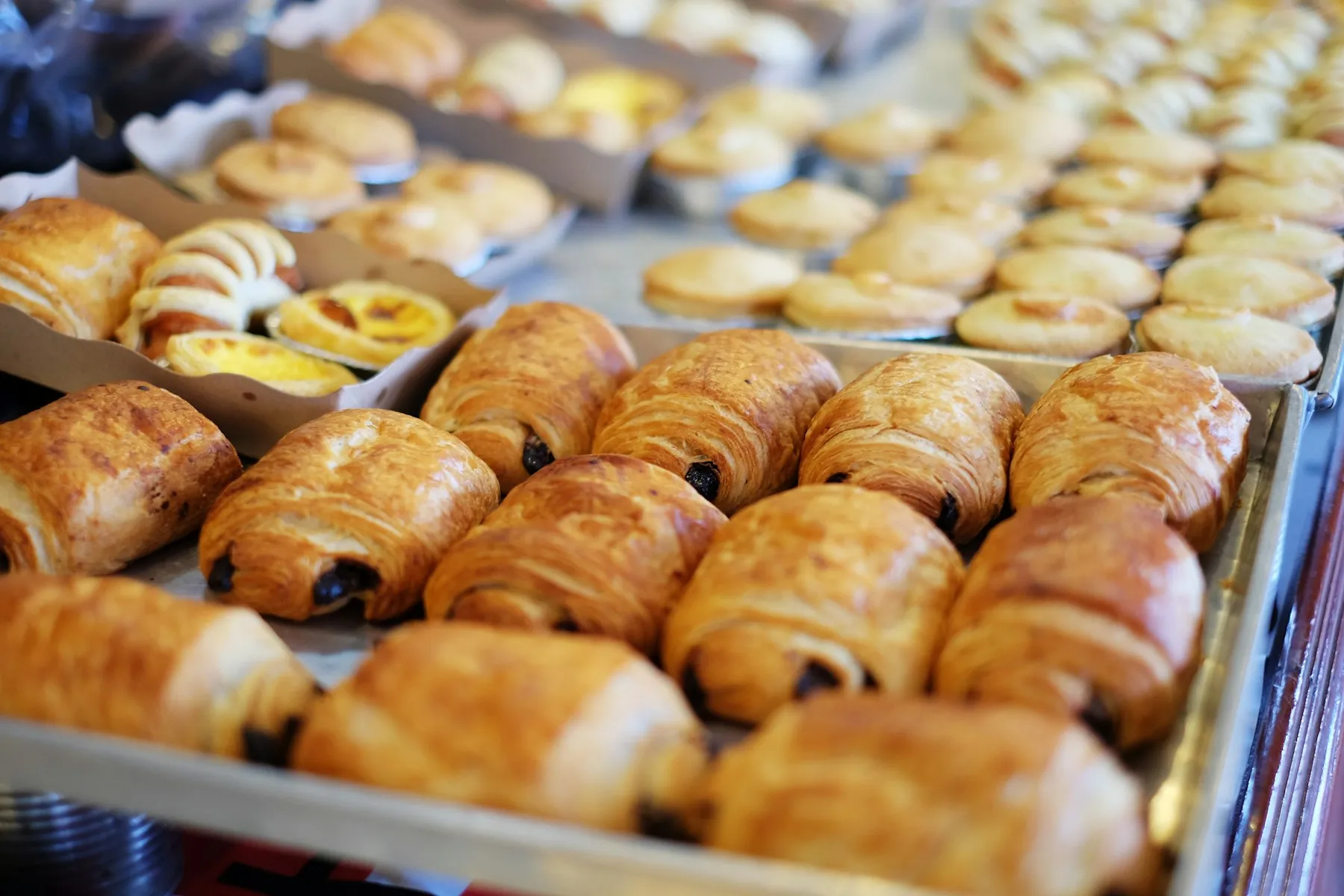 Plateau de viennoiseries dorées sortant du four